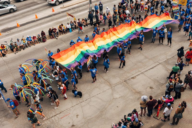 giant pride flag being hold during pride parade